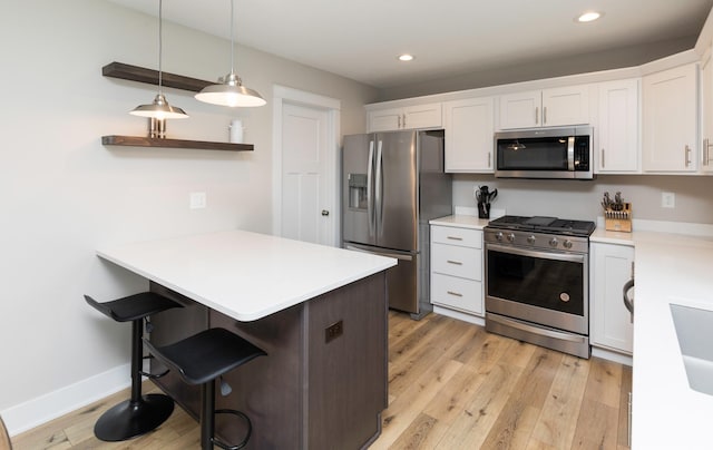 kitchen with a breakfast bar, white cabinets, a peninsula, and stainless steel appliances