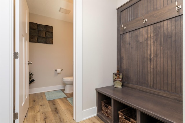 bathroom featuring hardwood / wood-style flooring, toilet, and baseboards