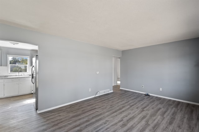 spare room featuring sink and dark hardwood / wood-style flooring