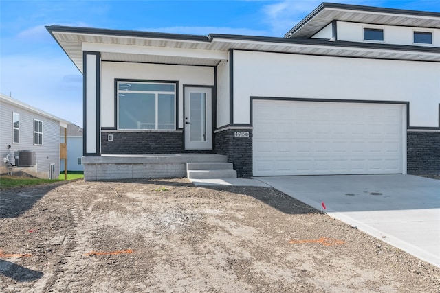 view of front of home featuring a garage and central AC