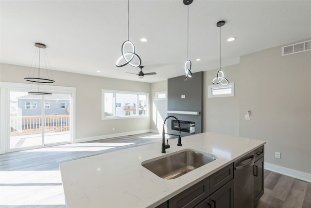 kitchen featuring pendant lighting, dishwasher, light wood-type flooring, and sink