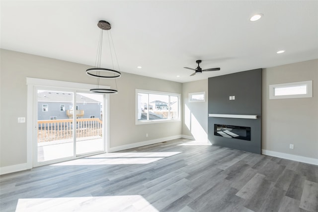 unfurnished living room with ceiling fan and light hardwood / wood-style floors