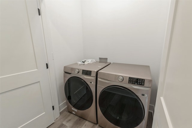 washroom featuring washer and clothes dryer and light hardwood / wood-style flooring