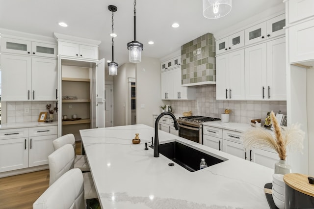 kitchen with pendant lighting, a breakfast bar, light stone counters, and sink