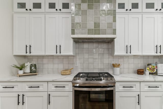 kitchen with backsplash, white cabinets, and stainless steel range oven