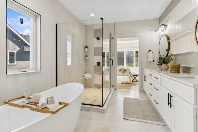 bathroom with tile patterned floors, vanity, and shower with separate bathtub