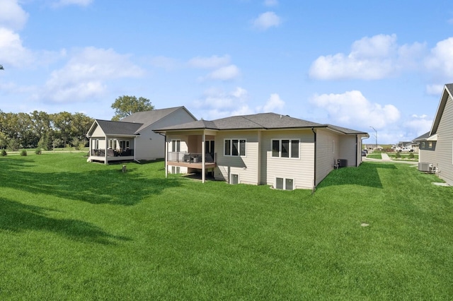 back of property featuring a lawn, central AC unit, and a wooden deck