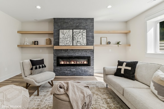 living room featuring a stone fireplace and hardwood / wood-style flooring