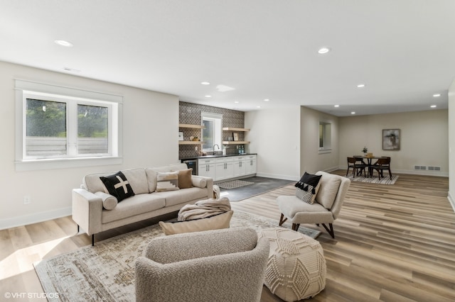 living room featuring sink and light hardwood / wood-style floors