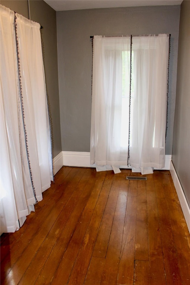 1510 9th St, Des Moines, IA 50314 - unfurnished room with wood-type flooring, visible vents, and baseboards