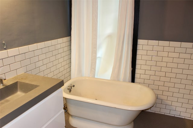 bathroom featuring vanity, tile walls, and a tub