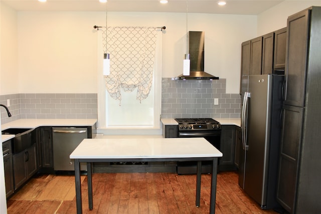 kitchen featuring sink, wall chimney exhaust hood, light hardwood / wood-style flooring, stainless steel appliances, and decorative backsplash