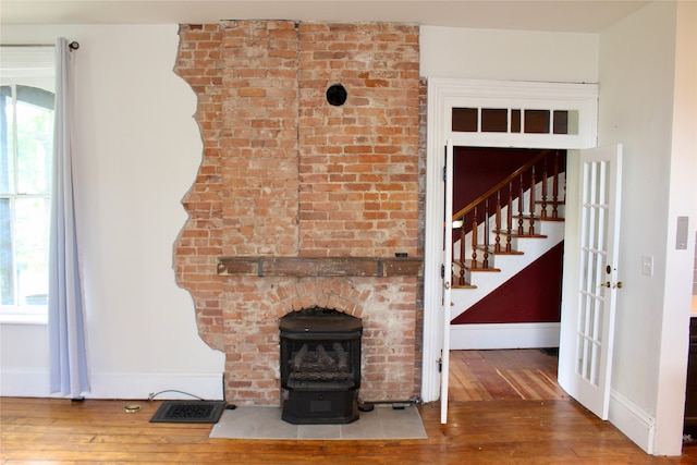 unfurnished living room featuring hardwood / wood-style flooring and a wood stove