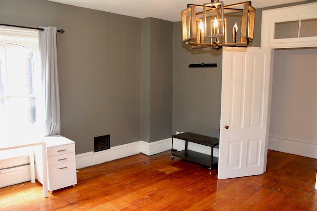 interior space with wood-type flooring and a notable chandelier