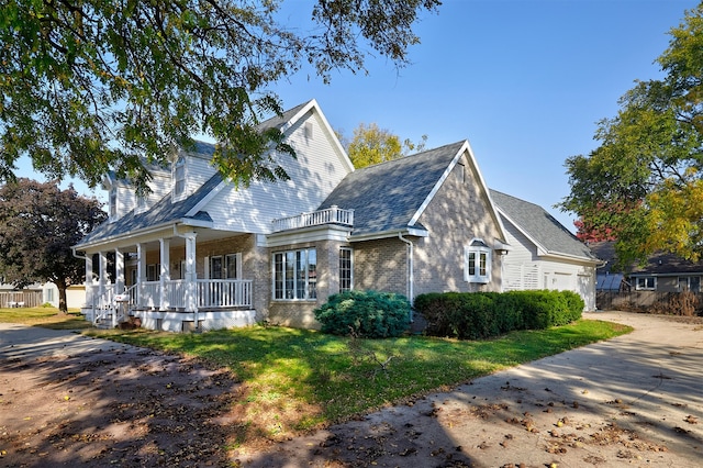 view of side of property with a yard, a balcony, and a porch