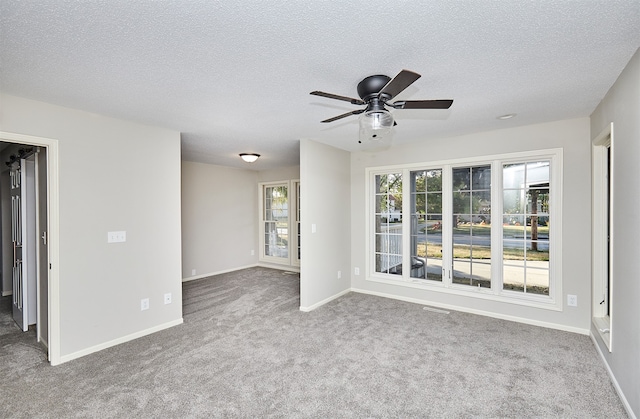 spare room featuring ceiling fan, a textured ceiling, and carpet flooring