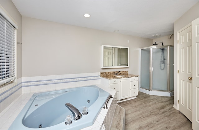 bathroom featuring wood-type flooring, separate shower and tub, and vanity