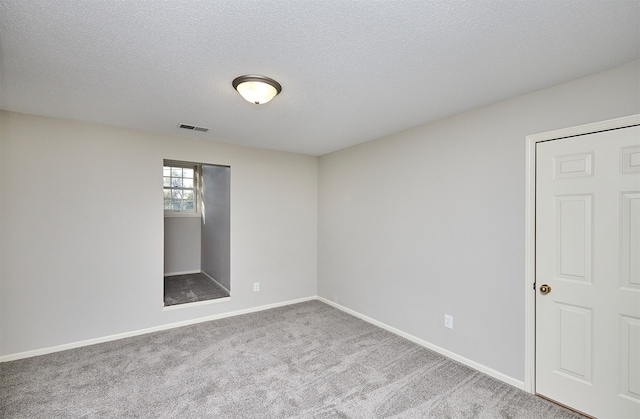 empty room featuring carpet flooring and a textured ceiling