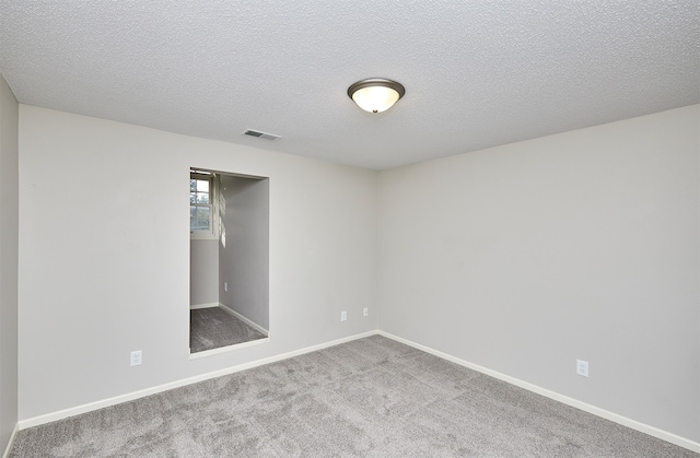 unfurnished room with a textured ceiling and carpet flooring