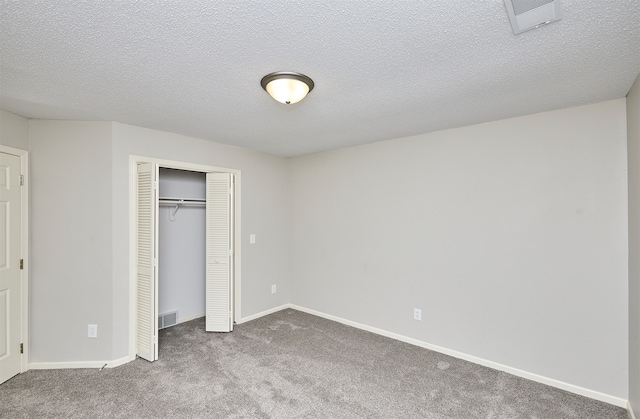 unfurnished bedroom featuring a closet, carpet, and a textured ceiling