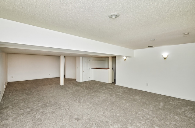 basement featuring carpet floors and a textured ceiling