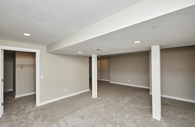 basement featuring carpet and a textured ceiling