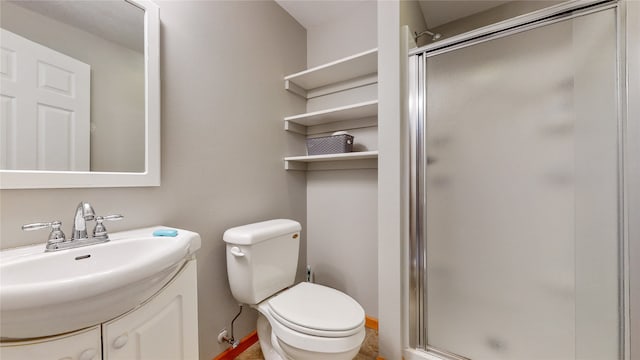 bathroom featuring a shower with door, vanity, and toilet