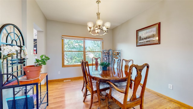 dining space with light wood-type flooring and a chandelier