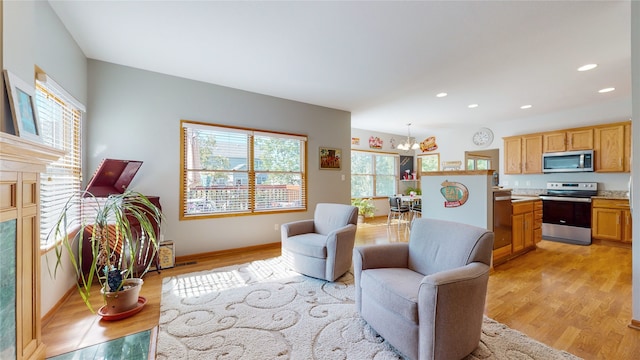 living room with an inviting chandelier and light hardwood / wood-style flooring