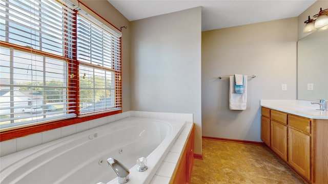 bathroom featuring a relaxing tiled tub and vanity