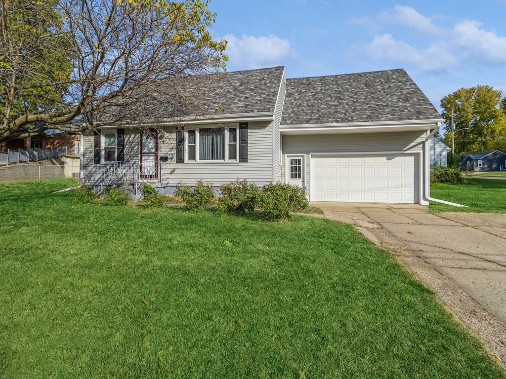 ranch-style house featuring a front yard and a garage