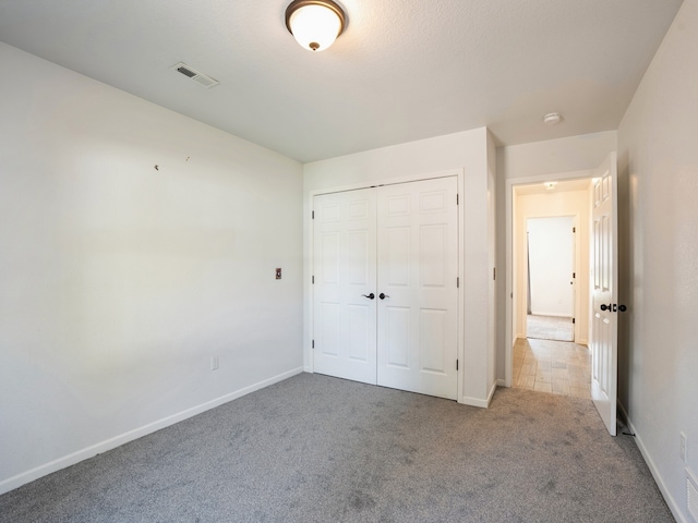 unfurnished bedroom with carpet floors and a closet