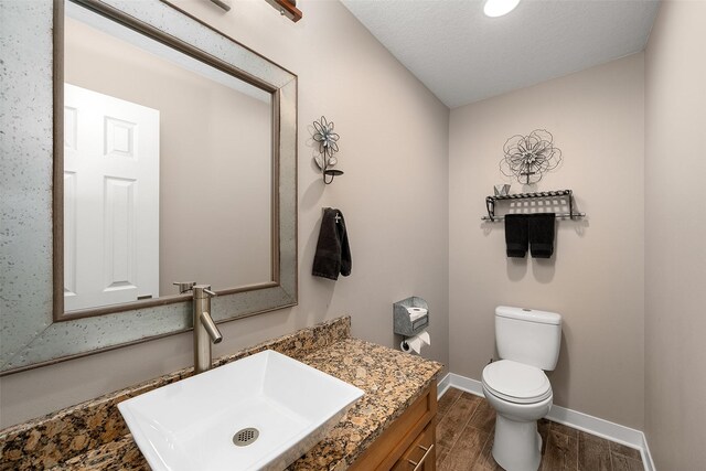 bathroom featuring vanity, toilet, and a textured ceiling