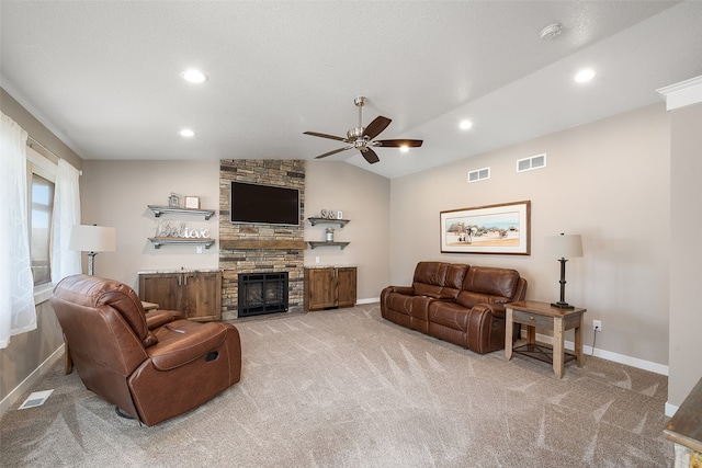 living room with a fireplace, light colored carpet, vaulted ceiling, and ceiling fan