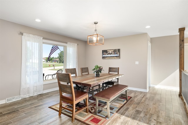 dining area with a chandelier and wood-type flooring