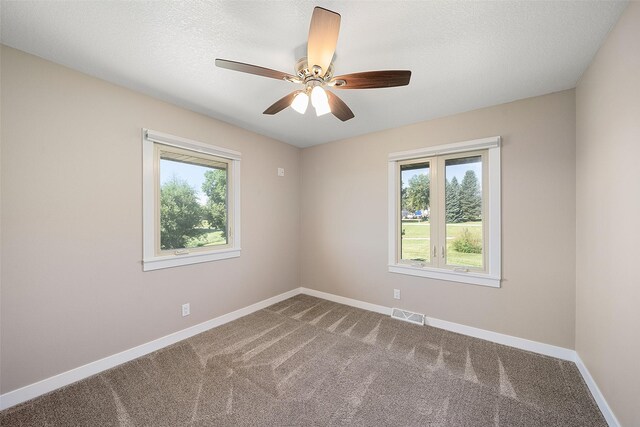 carpeted empty room featuring ceiling fan and a textured ceiling