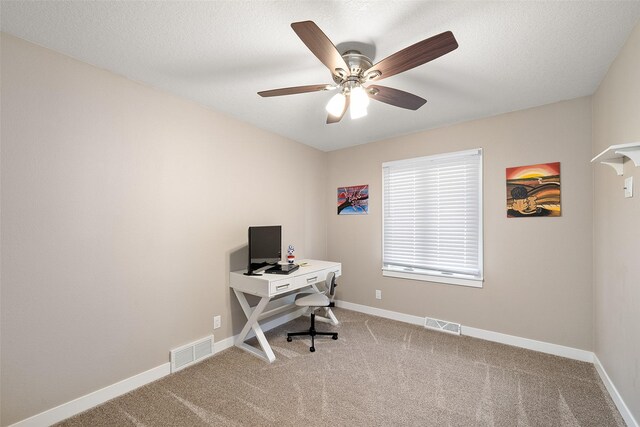 carpeted office space featuring ceiling fan and a textured ceiling