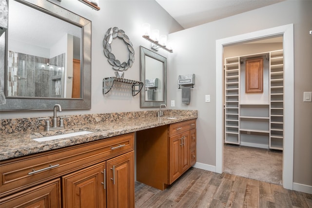 bathroom featuring a shower, vanity, and hardwood / wood-style flooring