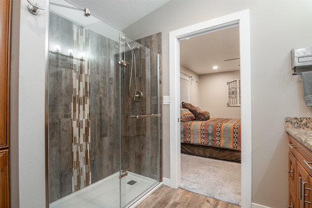 bathroom featuring a shower with door, vanity, and wood-type flooring