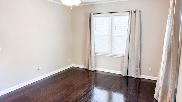 empty room featuring ornamental molding and dark wood-type flooring