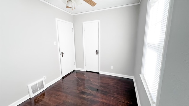 empty room featuring dark hardwood / wood-style floors, a healthy amount of sunlight, and ornamental molding