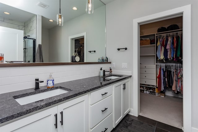 bathroom with tile patterned flooring, an enclosed shower, backsplash, and vanity