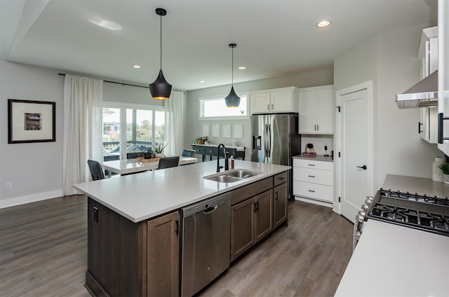 kitchen featuring a center island with sink, sink, dark hardwood / wood-style floors, appliances with stainless steel finishes, and white cabinetry