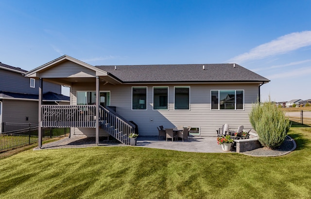 rear view of property with a lawn and a patio