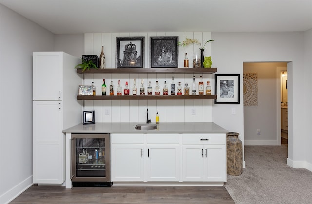 bar with beverage cooler, dark hardwood / wood-style floors, sink, and white cabinetry