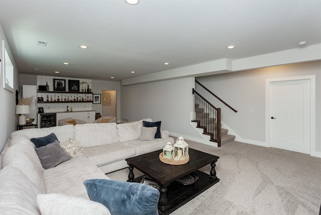 carpeted living room with beverage cooler and bar