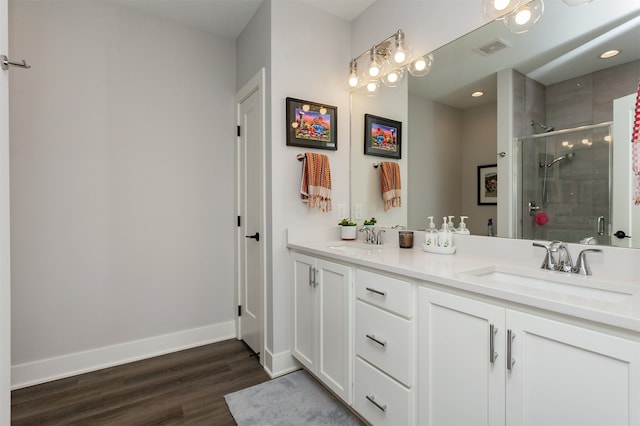 bathroom featuring hardwood / wood-style flooring, a shower with door, and vanity