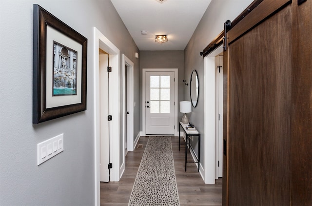 doorway with dark hardwood / wood-style floors and a barn door