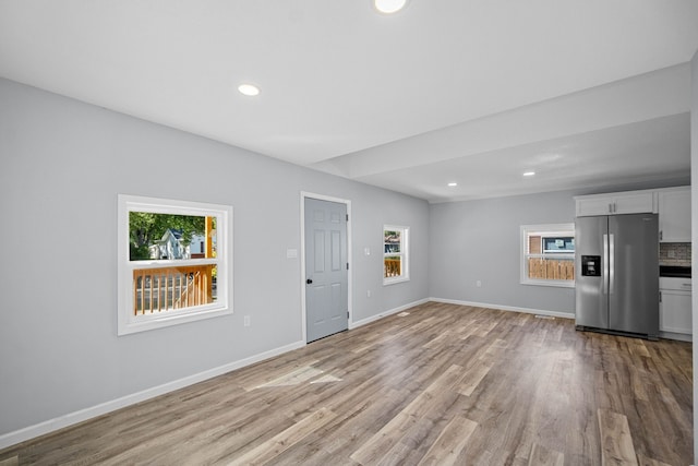 unfurnished living room with light hardwood / wood-style flooring and a healthy amount of sunlight