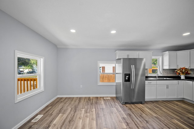 kitchen with stainless steel fridge, plenty of natural light, and light hardwood / wood-style flooring